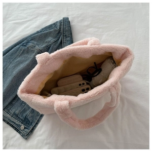 Vue intérieure montrant la grande capacité du sac fourre-tout en peluche rose avec doublure