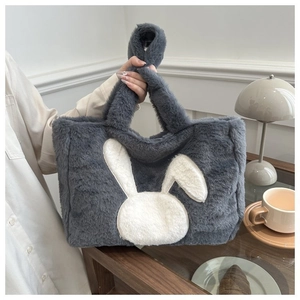 Gros plan du sac cabas en peluche gris avec broderie lapin blanc et texture douce