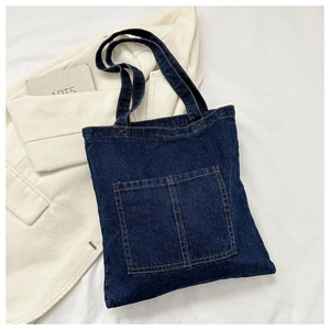 Detail of dark blue denim tote bag with two front pockets and contrast stitching