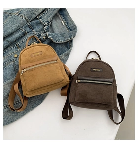 Détails de mini sacs à dos en daim marron avec poches zippées sur veste en jean