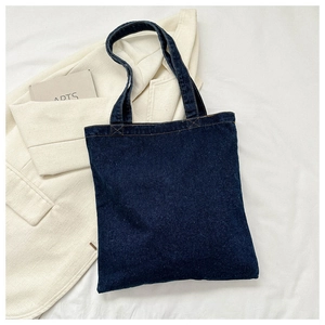 Detail of blue denim tote bag featuring precision contrast stitching and large capacity