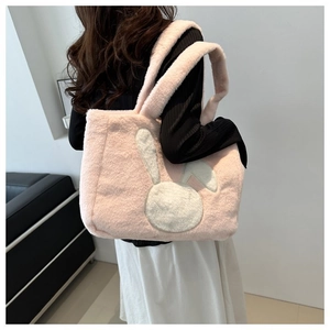 Sac cabas en peluche rose avec écusson lapin blanc porté par un mannequin en studio