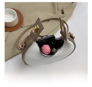 Interior view of white woven crescent bag showing spacious capacity and gold hardware