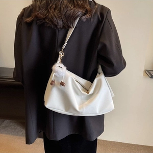 White pebbled leather hobo shoulder bag with a cute plush charm and minimalist design