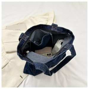 Detail of spacious denim tote interior with zipper pocket and storage capacity