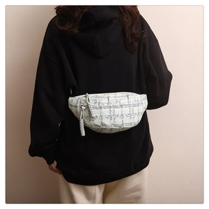 Detailansicht der karierten Tweed-Gürteltasche mit Reißverschluss an schwarzem Hoodie