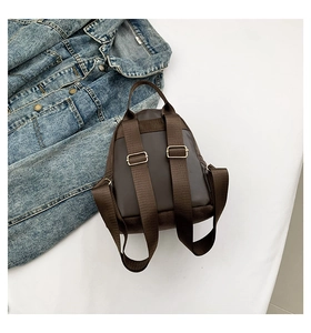 Détail d'un mini sac à dos marron foncé avec bretelles en nylon et boucles métalliques