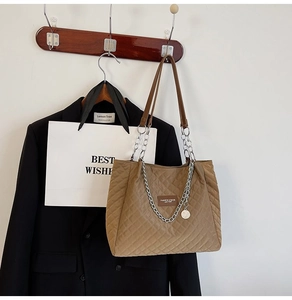 Détail du sac cabas matelassé marron avec anses en cuir et chaîne en métal