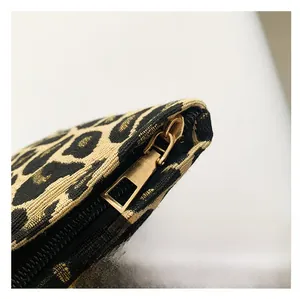 Close-up of high-quality light gold metal zipper on leopard print canvas bag detail