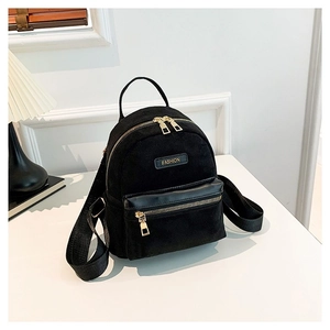 Mini sac à dos noir minimaliste pour femme avec détails dorés sur un support blanc