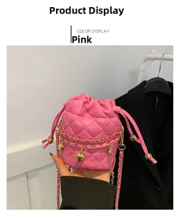 Detail of pink quilted bucket bag with gold chain and heart pendant drawstring closure