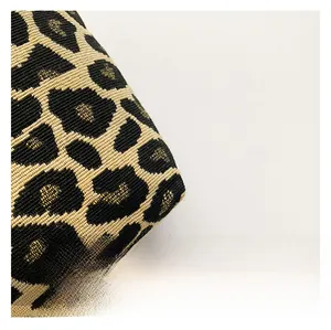 Detailed close-up of leopard pattern jacquard fabric with golden glitter thread weaving