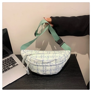 Detailansicht der Tweed-Karostruktur und des Doppelreißverschlusses der grünen Tasche