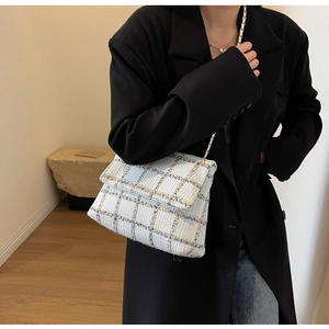 Vue détaillée du sac en tweed à carreaux blanc et bleu avec chaîne dorée sur mannequin