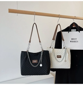Vue détaillée des sacs cabas matelassés avec bandoulières chaînes et écussons en cuir