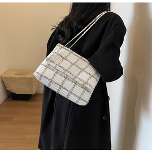 Détail du sac bandoulière en tweed à carreaux bleus et jaunes avec bandoulière à chaîne