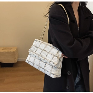 Vue détaillée du sac bandoulière en tweed blanc avec chaîne dorée sur blazer noir