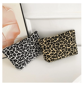 Detailed view of leopard print woven square pouches in classic tan and modern monochrome