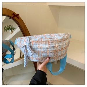Detailaufnahme der blau-orangen Karo-Gürteltasche mit gewebtem Reißverschlussanhänger