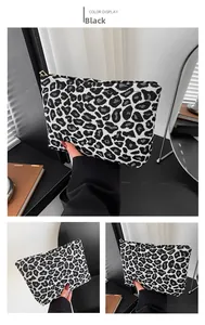 Detail of leopard print mini pouch with black and white animal pattern and gold zipper