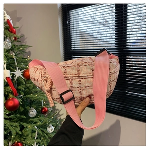 Detaillierte Nahaufnahme der rosa Tweed-Gürteltasche mit Webstruktur und Gurt