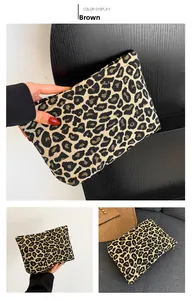 Detailed close-up showing the leopard print fabric texture and zipper on the clutch bag