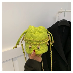 Close-up of quilted neon green bucket bag with gold chain and heart charm detail