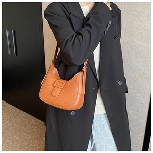 French retro brown crocodile pattern half-moon bag worn with black blazer