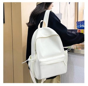 Zaino bianco minimalista con tasca a coulisse e dettaglio cerniera indossato dal modello