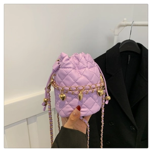 Close-up of purple quilted bucket bag with golden chain strap and heart charm