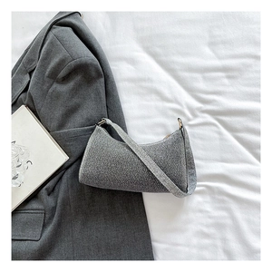 Detail der silbernen Pailletten-Hobo-Tasche mit Reißverschluss auf weißem Stoff