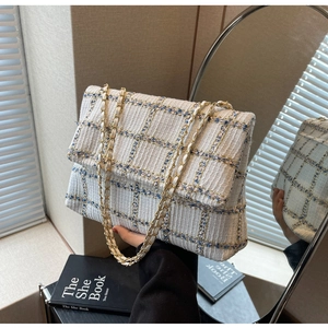 Vue détaillée de la texture du tissu en tweed blanc et bleu du sac à chaîne