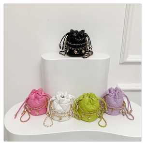 Close-up of mini quilted bucket bags with gold chain straps and heart charms in 5 colors
