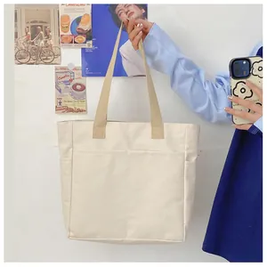 Vue détaillée du sac cabas en toile avec poches avant et anses en toile beige