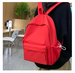 Vista posteriore di un modello con uno zaino in nylon rosso ad alta capacità per studenti