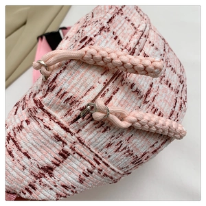 Detail der rosa-weißen karierten Brusttasche mit Kordel-Reißverschluss und Kunststoffschnalle