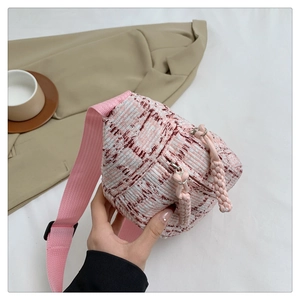 Detailansicht der rosa karierten Tweed-Umhängetasche mit gewebten Riemen und Reißverschluss