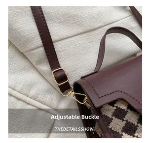 Detailansicht der goldener Metallschnalle und des braunen Lederriemens der Handtasche