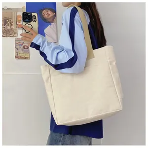 Détail d'un grand sac fourre-tout en toile beige avec sangles kaki et poche latérale pratique