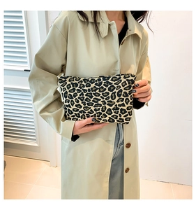 Fashion leopard print canvas clutch bag held by model showing size and texture