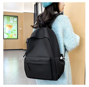 Vista laterale di uno zaino nero minimalista con tasche laterali funzionali con coulisse bianca