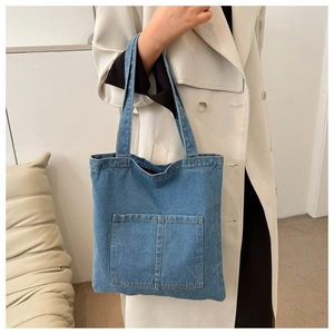 Detailed view of casual blue denim tote bag texture and front functional pockets