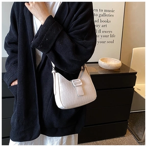 Close-up of white crocodile pattern shoulder bag on a model with a retro vibe