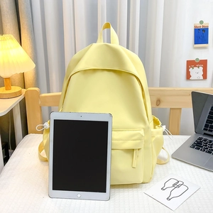 Dettaglio dello zaino minimalista giallo con tasca frontale e spazio per contenere un tablet