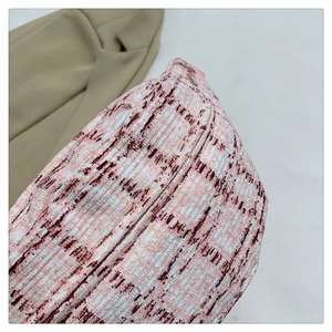 Detailansicht der karierten Strickstofftextur in rosa und rötlichen Farbtönen