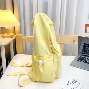 Dettaglio dello zaino giallo chiaro con tasca laterale con coulisse e tracolla regolabile