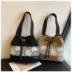 Detail of canvas bucket bags with circular floral prints and adjustable drawstring closures
