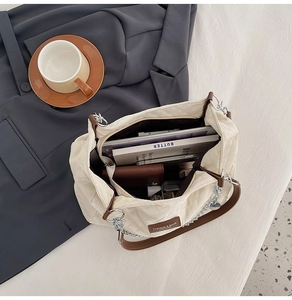 Détail intérieur du grand sac cabas matelassé contenant des livres et magazines