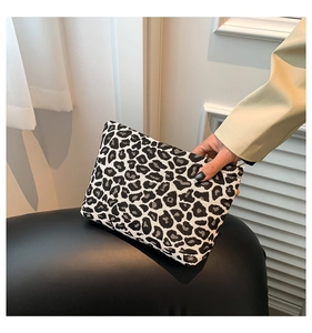 Close-up of stylish leopard print fabric clutch bag with secure zipper closure for women