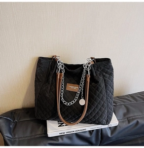 Sac cabas noir matelassé avec poignées en cuir marron et chaîne argentée élégante